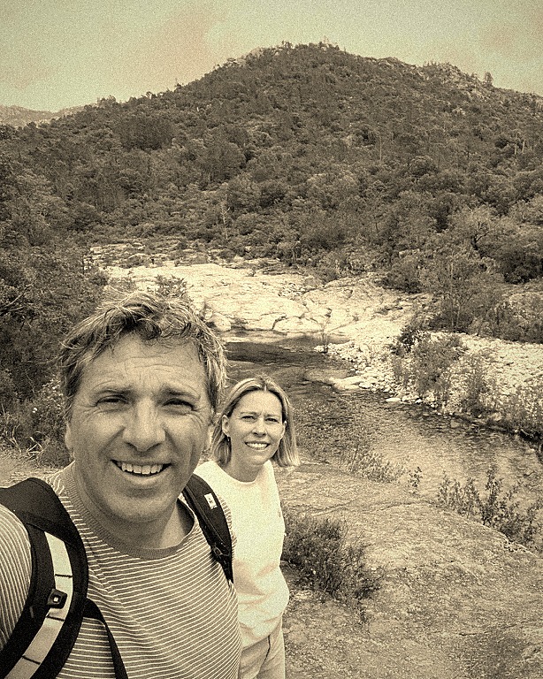 Geert & An taking a selfie on a rocky riverbank in the mountains
